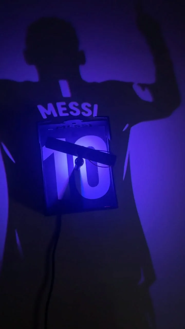 Number-10 shadow lamp mounted over the back of a large raised-arm footballer silhouette